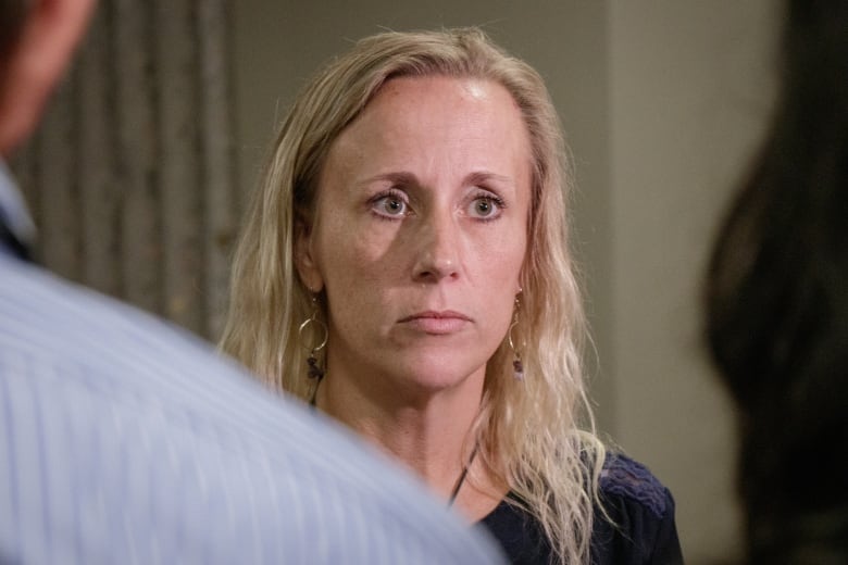 A woman stands outside a courtroom.