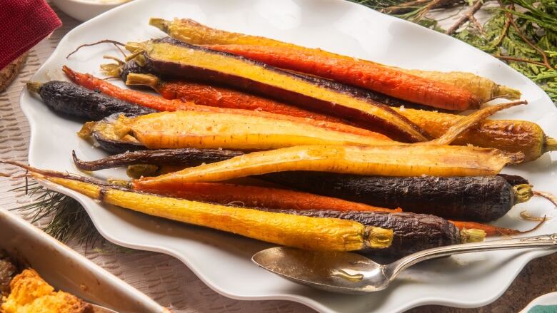 Roasted heirloom carrots on a white serving platter.