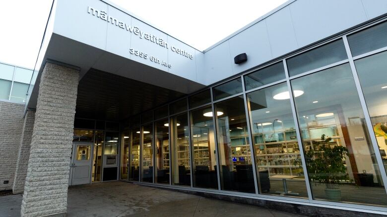 A new building with glass doors and is bright colors and has brick posting.