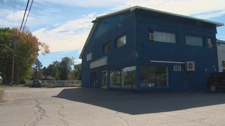 A blue commercial building and an empty parking lot.