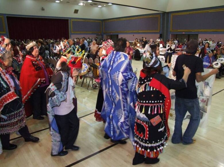 People in traditional regalia dance.