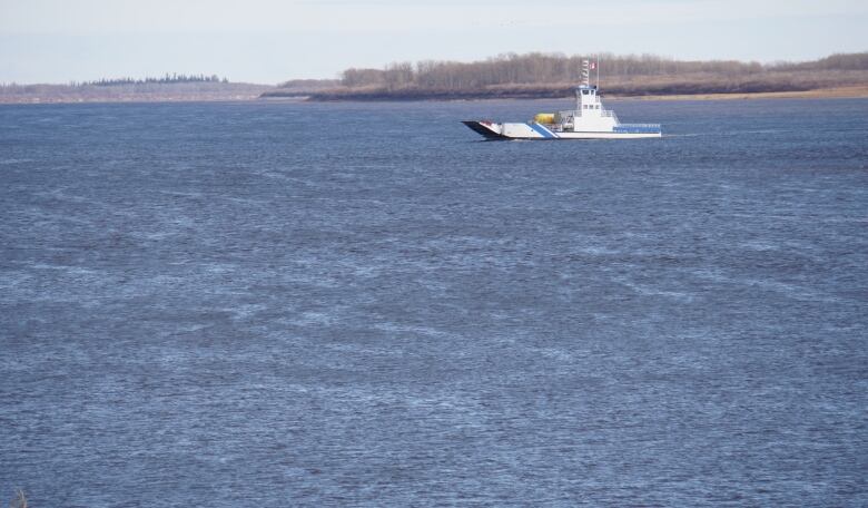 A white ferry crosses a big wide river