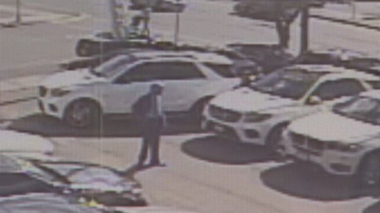 Surveillance camera image of vehicles in a dealership lot.   