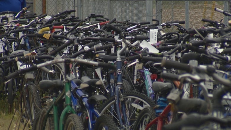 hundreds of bikes lined up against a fence