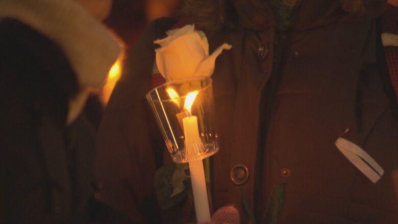 A candle, rose and white ribbon at a vigil on the 30th anniversary of the 1989 cole Polytechnique tragedy Friday, Dec. 6, 2019 in Ottawa.