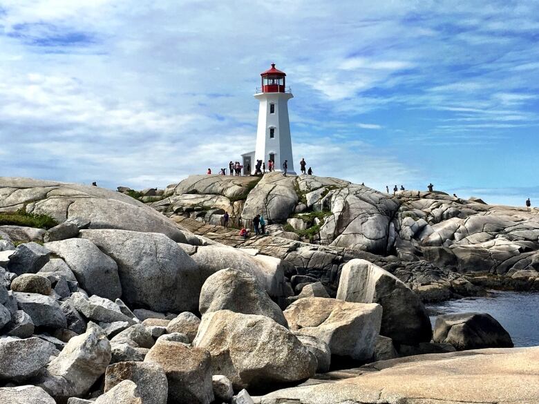 The Peggys Cove lighthouse is seen with rocks in the foreground