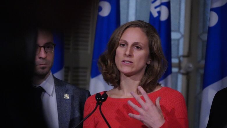 blonde white woman wearing a red shirt speaking at the National Assembly in Quebec