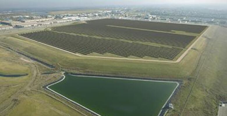 A conceptual drawing shows a large array of solar panels in a big field.