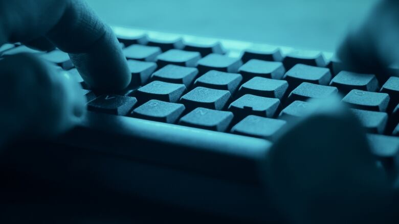 A person types on a computer keyboard.