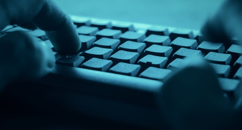 A person types on a computer keyboard.