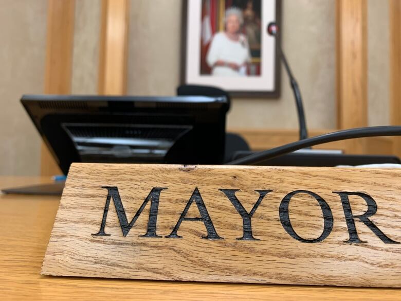 A wooden sign in a meeting room that says 