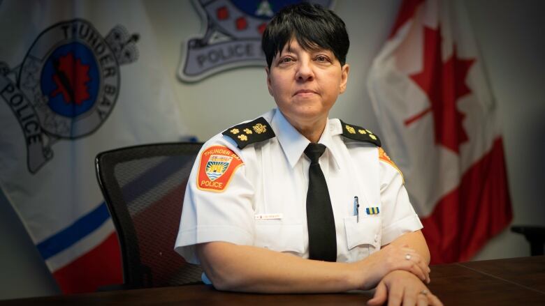 A woman in a police uniform poses for a photo. 