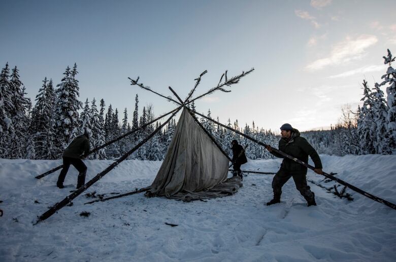 2 people raising a camp