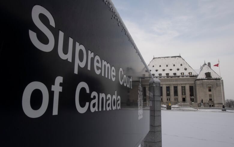 A sign reads 'Supreme Court of Canada' with snow on the ground and the court building in the background