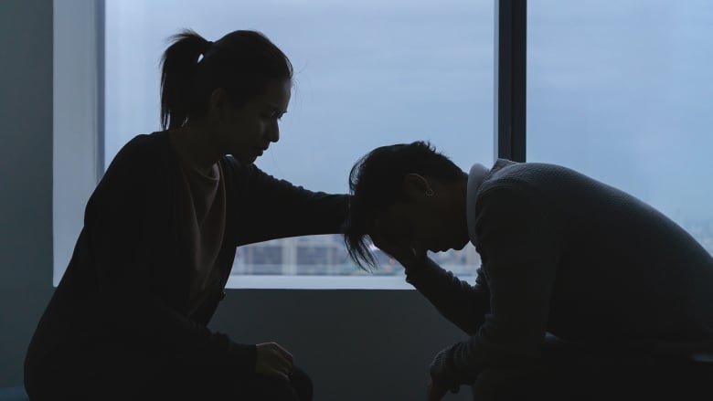 A woman comforts a person in distress. 