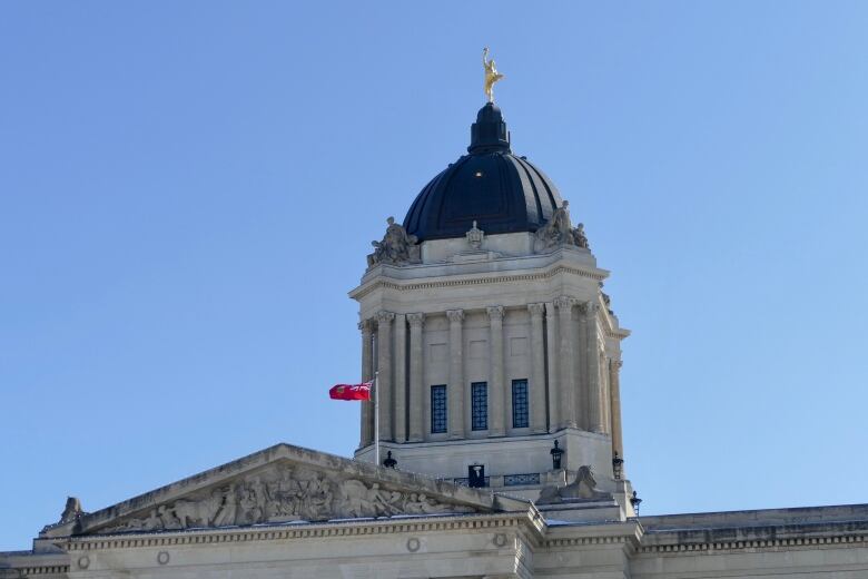 The domed top of a building is seen with a golden statue