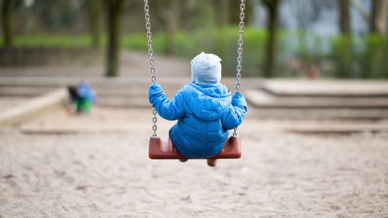 A toddler rocking on a playground.