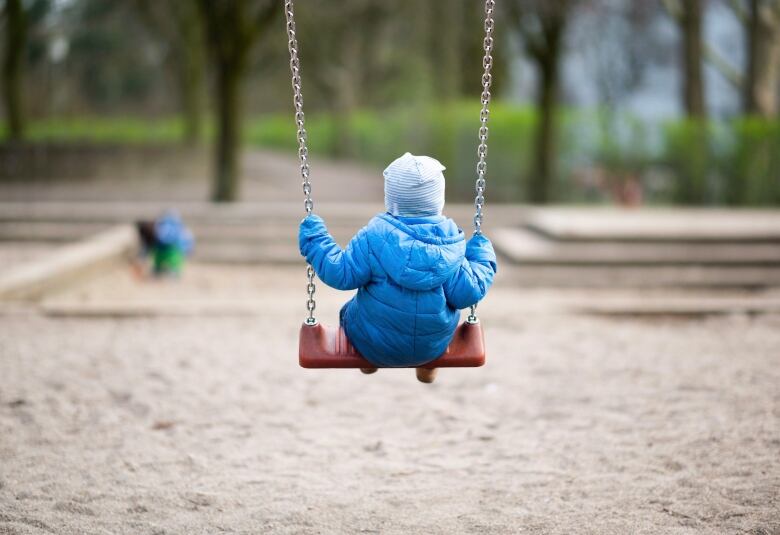 A toddler rocking on a playground.