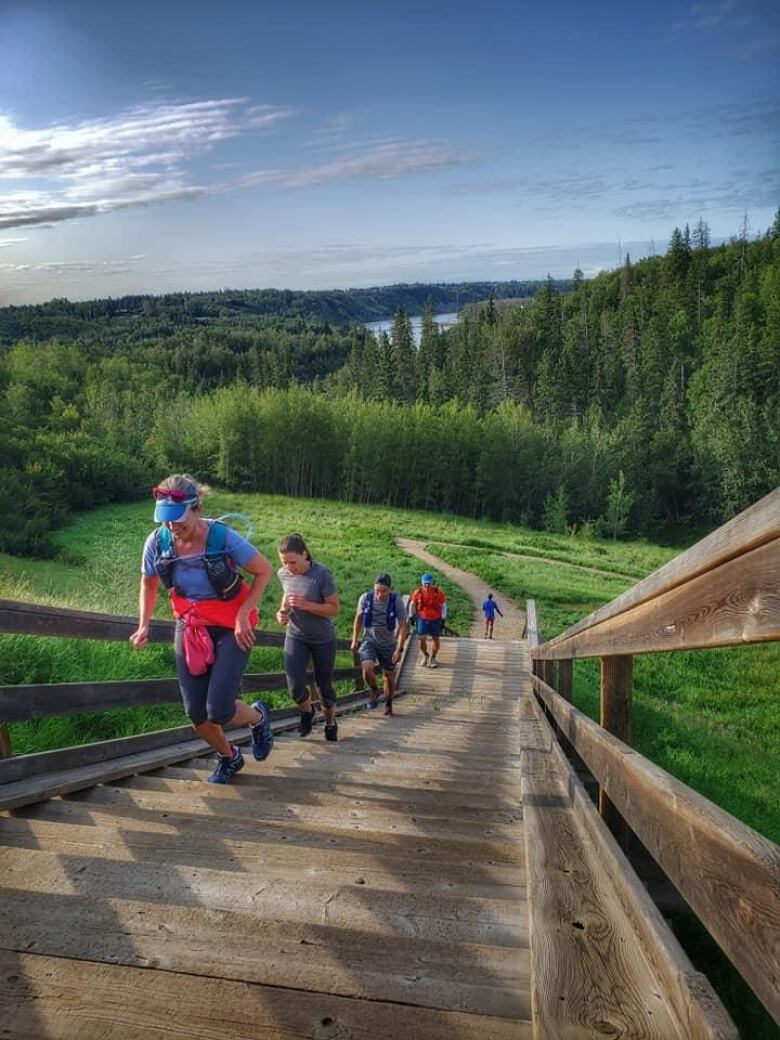 A group of runners climb a set of stairs on a sunny day near Edmonton's Rio Terrace neighbourhood. 