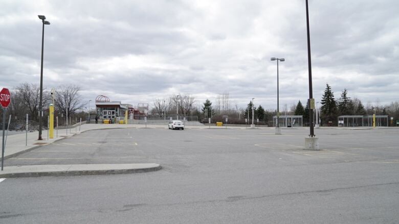 A mostly empty parking lot on a cloudy day.