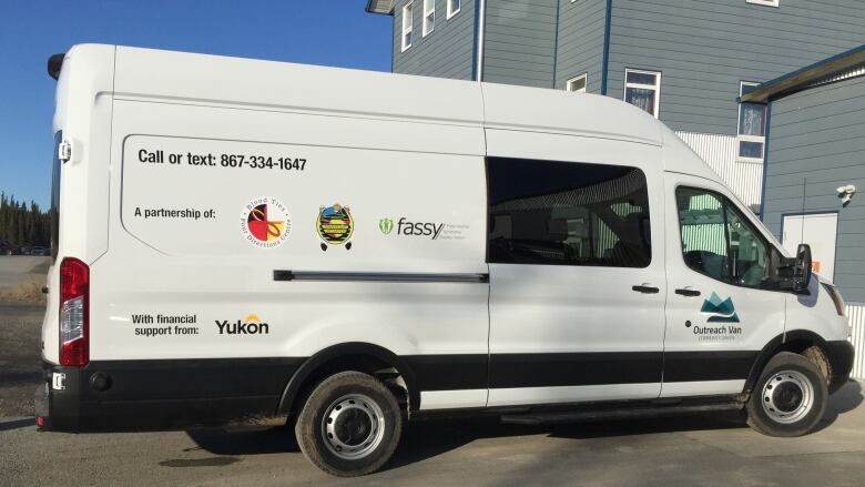 A white cube van parked infront of a building