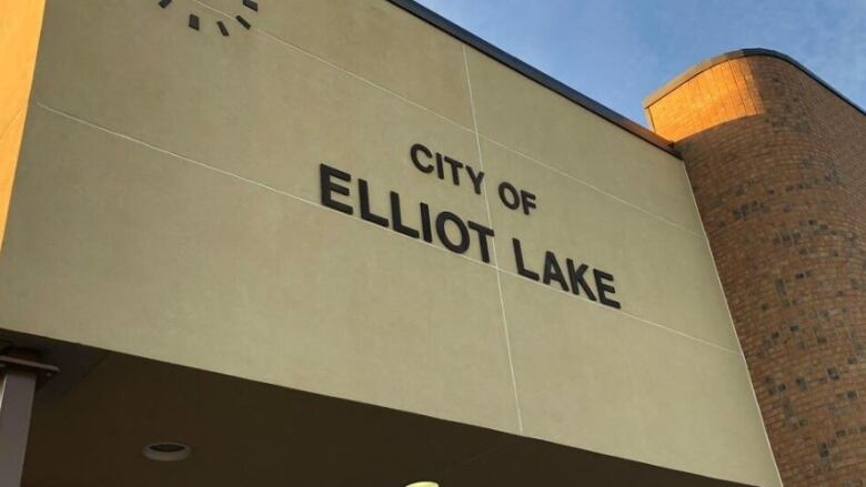 The side of a building features a clock and the words 'City of Elliot Lake'