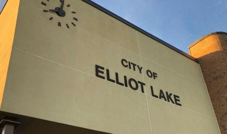 The side of a building features a clock and the words 'City of Elliot Lake'