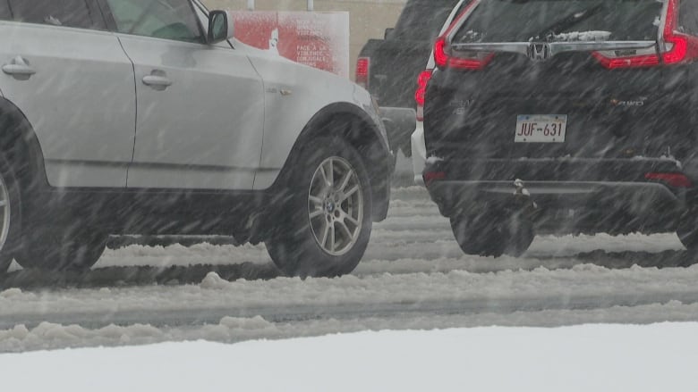 Cars drive through a slush-covered road