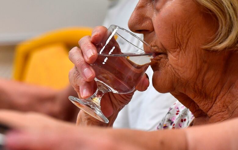 A woman drinking water from a glass.