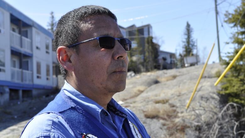 a man wearing sunglasses and beaded vest 