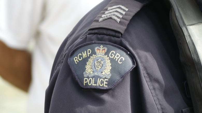 A closeup image shows a shoulder and a badge that says RCMP GRC Police.