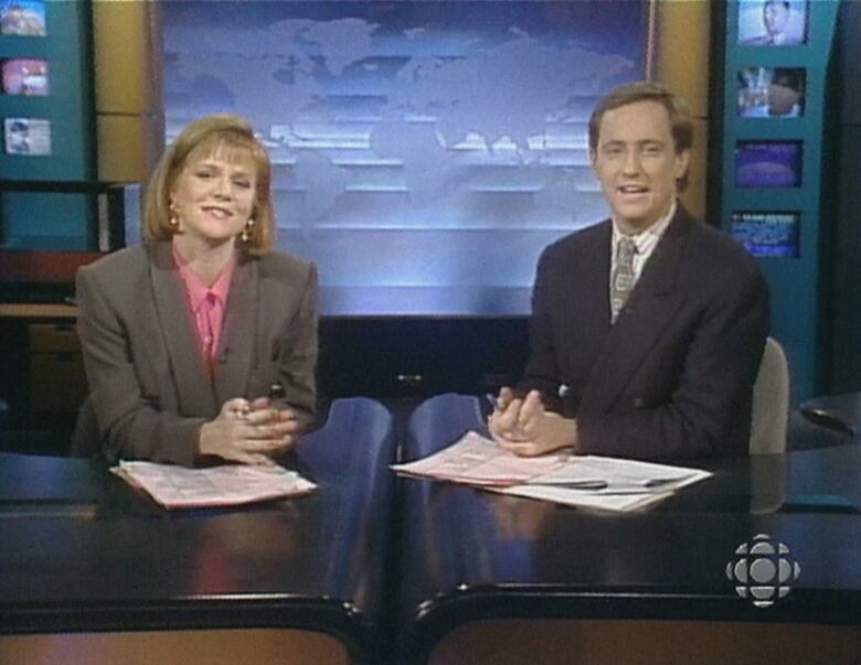 Woman and man at glossy desk on TV set