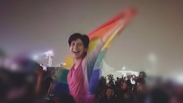 A friend captured a photo of Sarah Hegazi hoisting a rainbow flag at a concert in Cairo in 2017. She was arrested and tortured by the Egyptian authorities not long after.