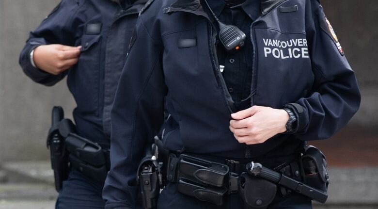 A close up picture of two Vancouver Police officers with jackets and walkie-talkies on their chests.