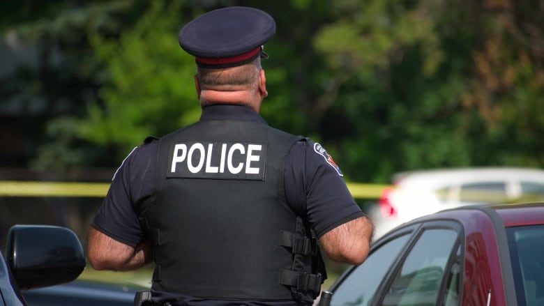 A man standing with crime tape in the background.