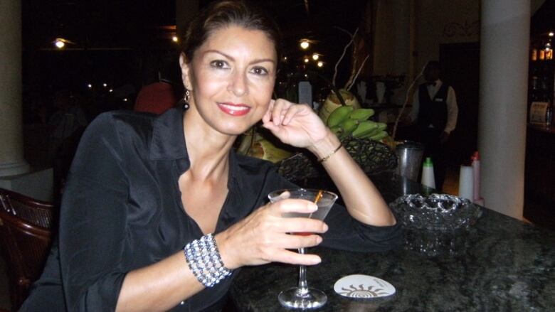 A woman holding a drink is pictured.