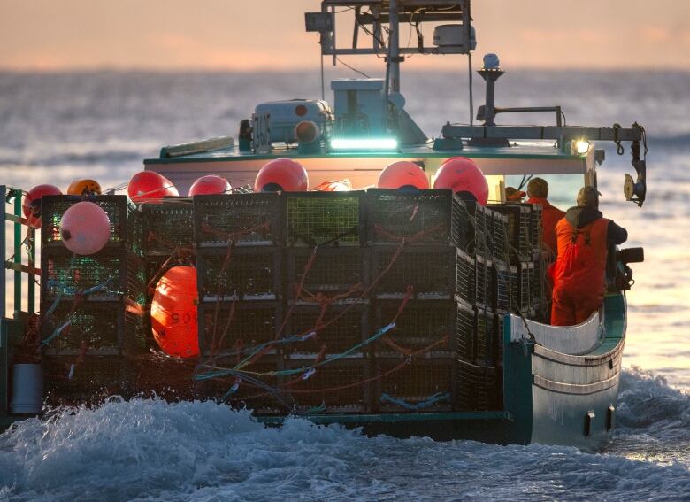 A fishing boat loaded with traps heads through the water.