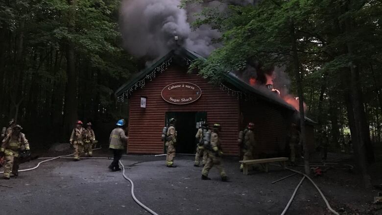 Firefighters fighting a fire at a sugar shack.