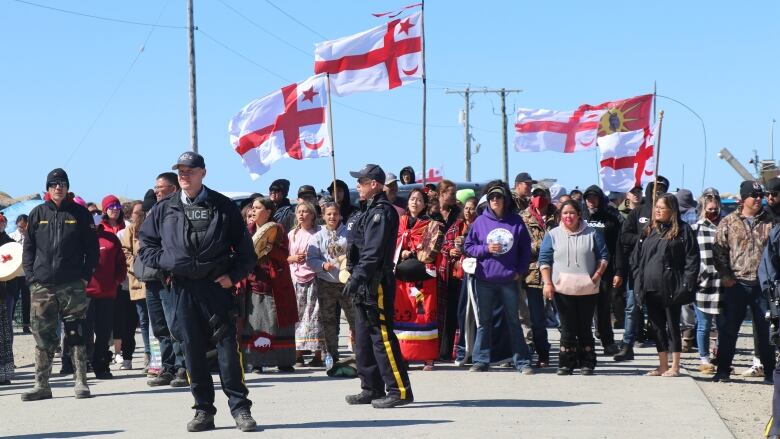 people holding flags near shore