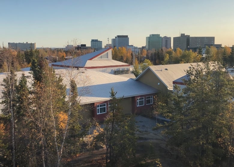 Buildings seen amid trees.