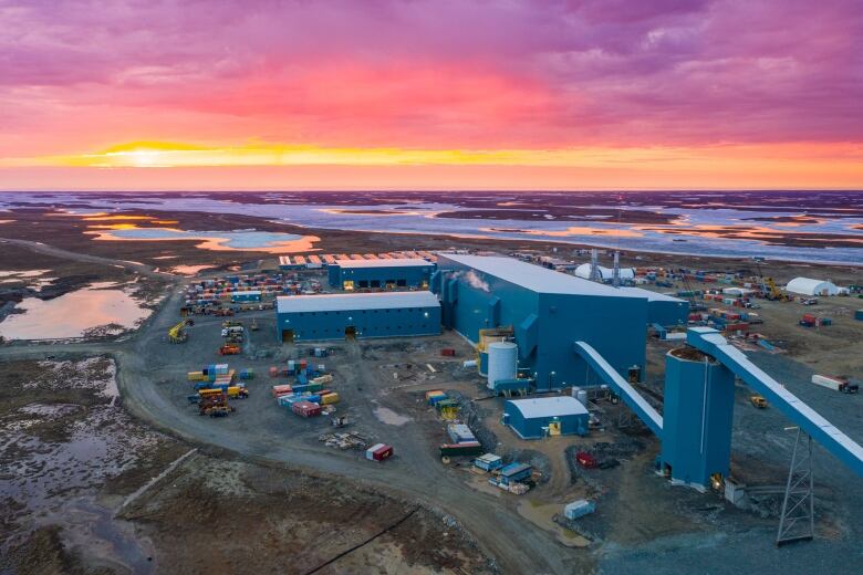 Buildings on tundra, red sky.