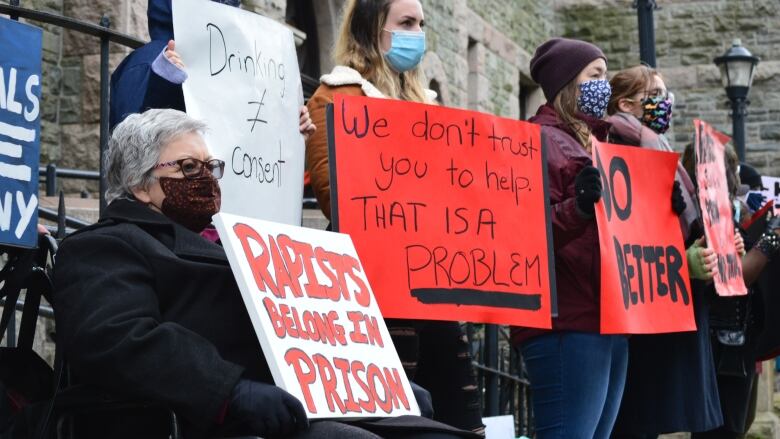 People holding signs outside court