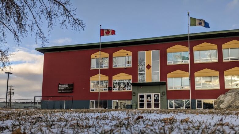 An outside shot of a red school building.