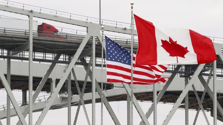 Canadian and American flags fly at the border.