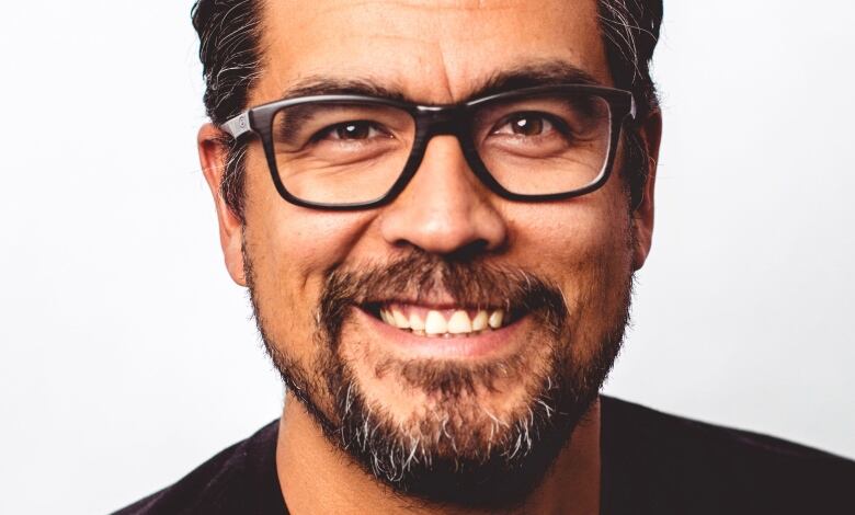 An Indigenous man smiles into the camera.