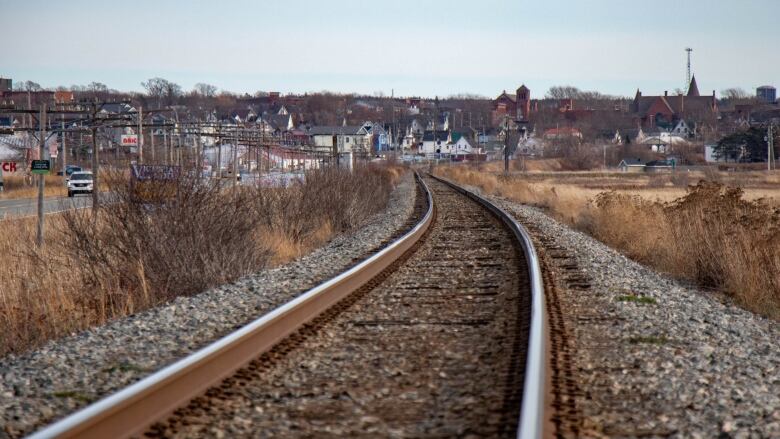 Train tracks can be seen in the foreground leadng to the Amherst skyline in the distance