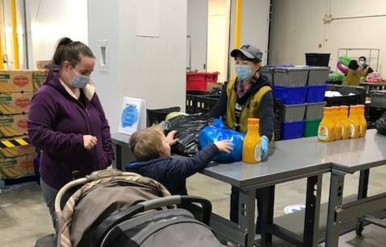 A woman and her child visit a food bank.