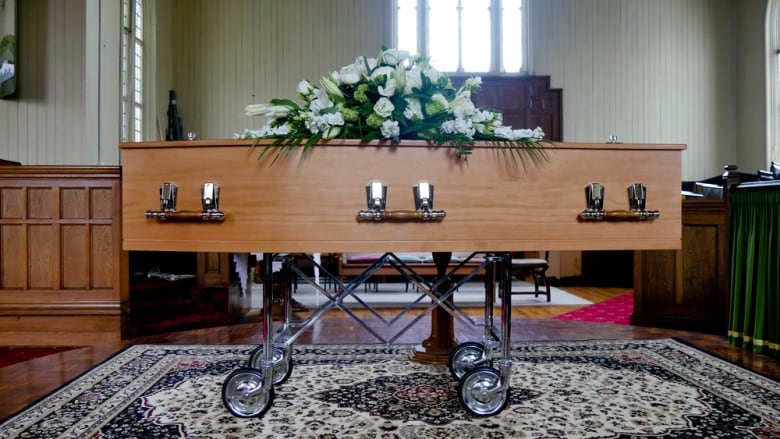 A wooden casket on top of a cart. 