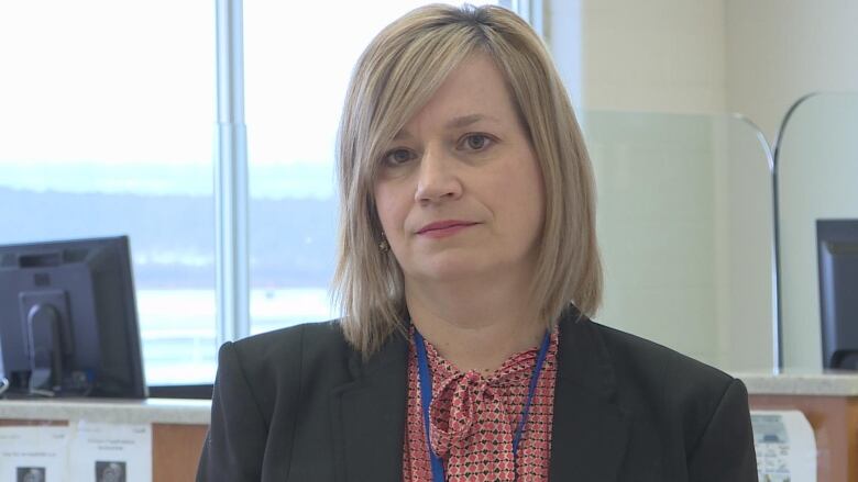 Woman with short blonde hair and blazer.