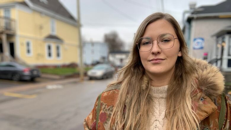 A woman stands in front of a city street.